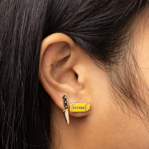 Butter and knife mismatched cloisonné stud earrings worn on ear by Yellow Owl Workshop