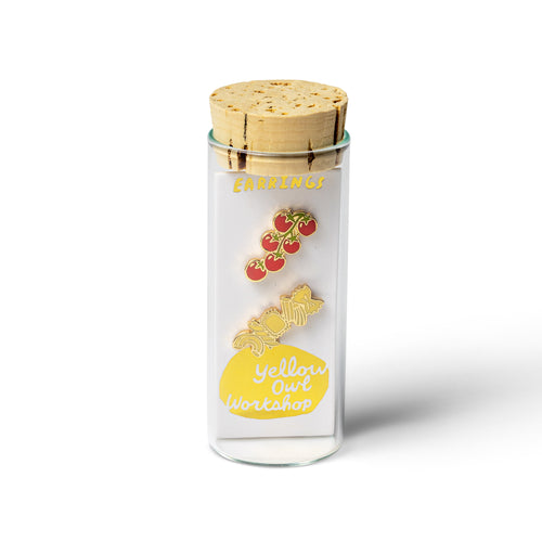 Yellow Owl Workshop tomatoes and pasta mismatched stud earrings displayed in a glass vial with cork stopper and branded packaging. Gold-tone enamel cherry tomato and pasta earrings, a fun food-inspired jewelry gift for pasta lovers, home cooks, and foodies.