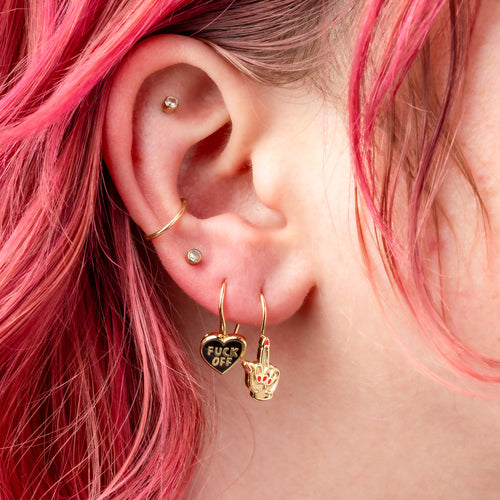 F*ck Off Heart and Middle Finger mismatched enamel drop earrings worn on ear by Yellow Owl Workshop