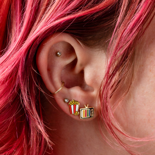 Movie night mismatched cloisonné stud earrings worn on ear by Yellow Owl Workshop