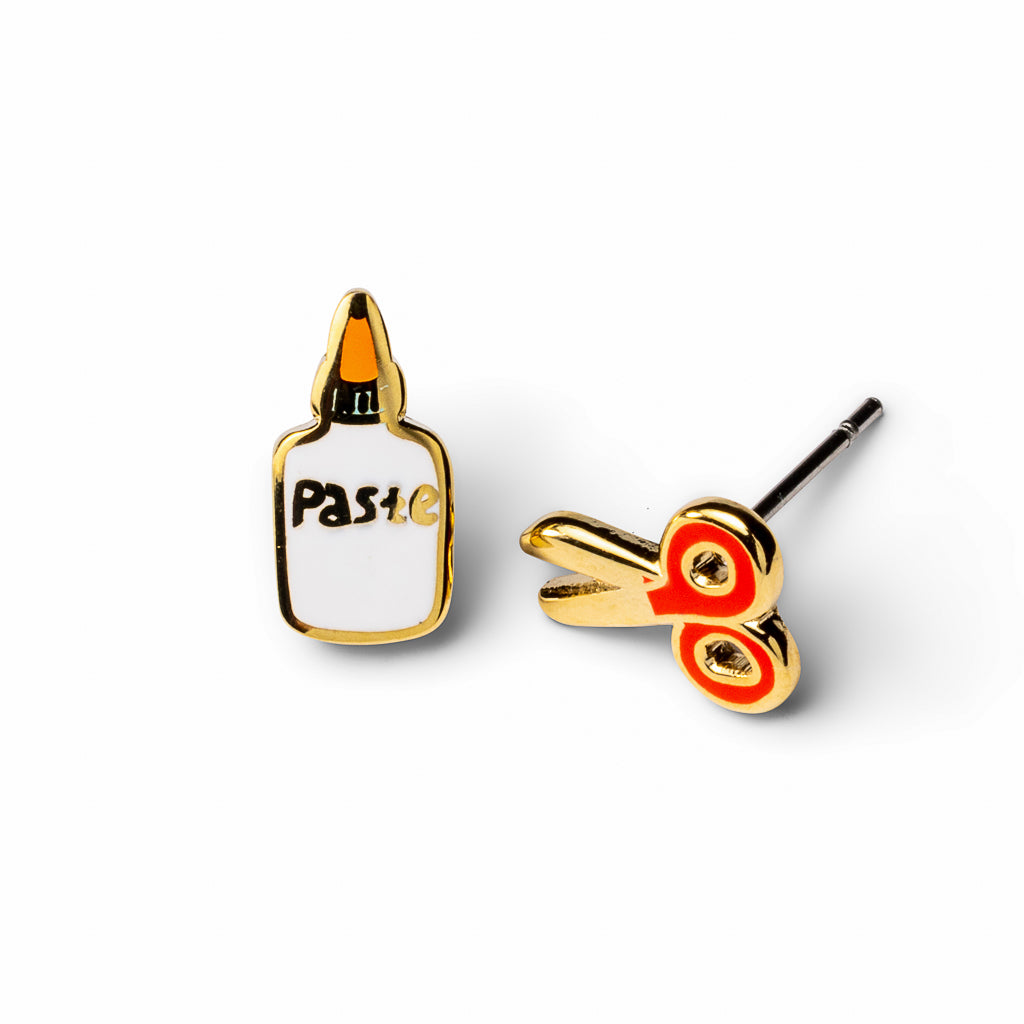 Mismatched cloisonné stud earrings featuring white paste bottle and gold red scissors gilded in 22 karat gold by Yellow Owl Workshop