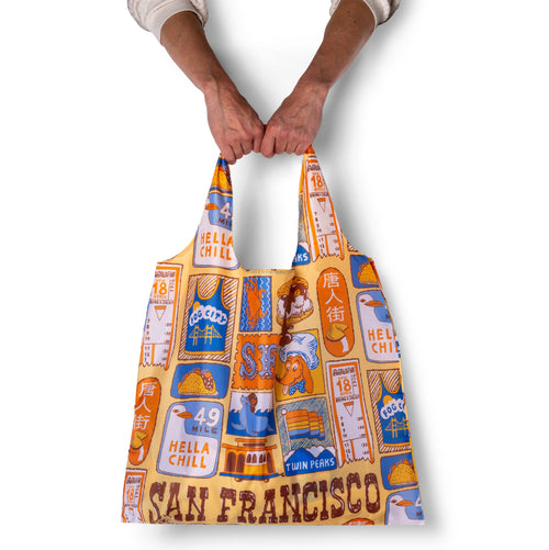 Person holding illustrated San Francisco tote bag with colorful SF landmark and icon print by Yellow Owl Workshop