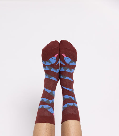 Burgundy Snake crew socks with blue snake and zigzag pattern worn on feet by Yellow Owl Workshop