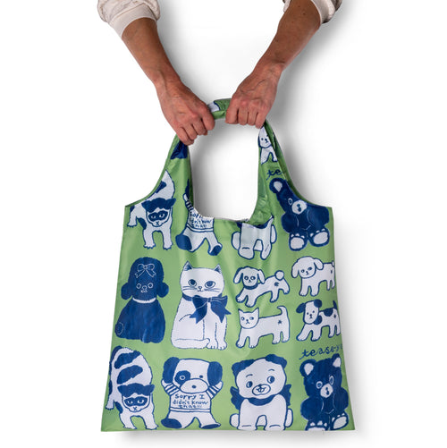 Person holding green illustrated cute animal tote bag with hand-drawn cats dogs and bears by Naon Jeong for Yellow Owl Workshop