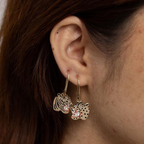 Tiger and Cheetah mismatched enamel drop earrings worn on ear by Yellow Owl Workshop
