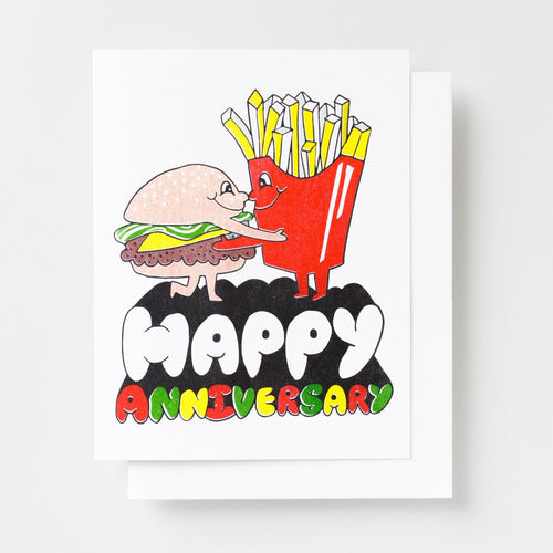 Risograph greeting card with illustrated burger and fries characters embracing on a white background, text reads Happy Anniversary in bold multicolor lettering