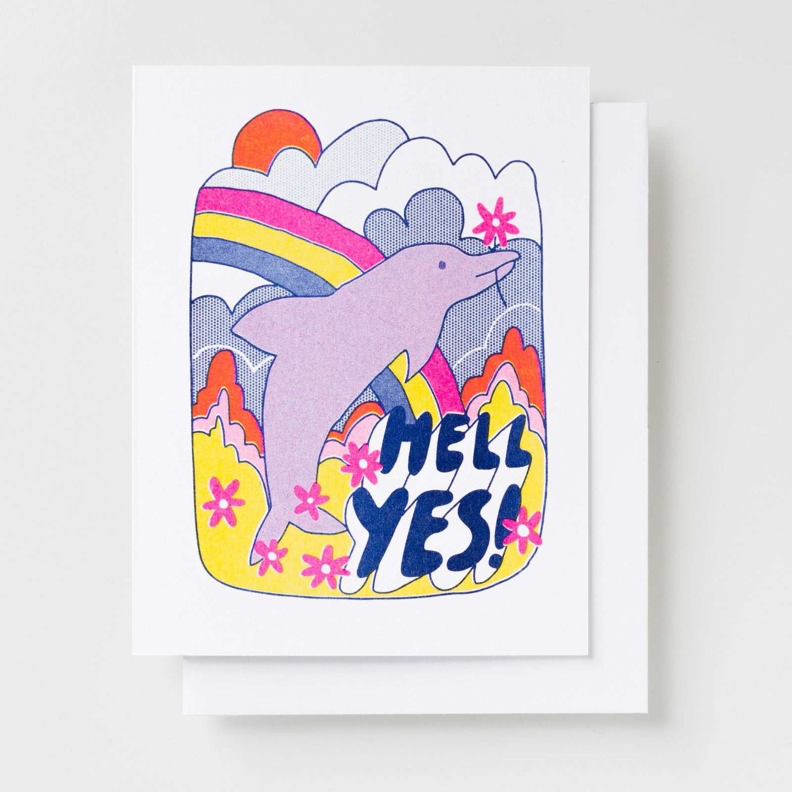 Risograph greeting card with an illustrated pink dolphin leaping through a colorful psychedelic landscape with a rainbow, clouds, and pink flowers, text reads Hell Yes in bold navy lettering