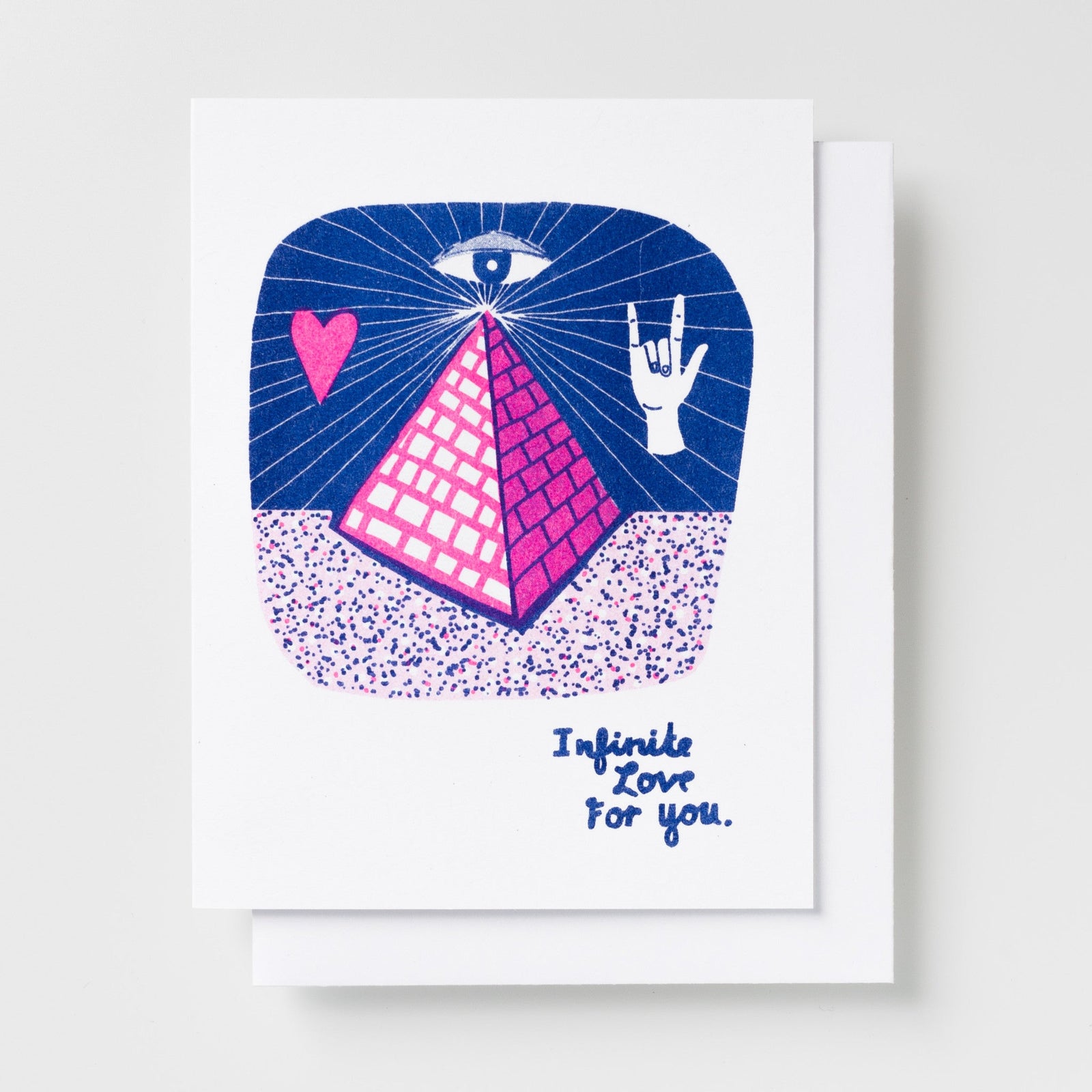 Risograph greeting card with an illustrated pink pyramid beneath an all-seeing eye with a heart and rock on hand gesture on a navy blue background, text reads Infinite Love For You in handwritten blue lettering