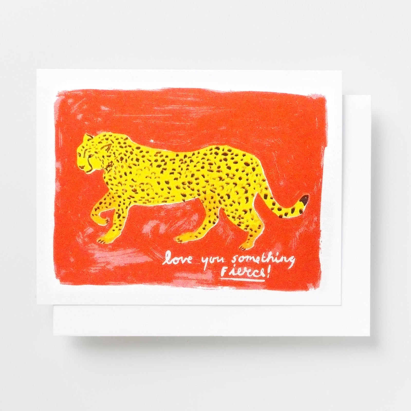 Risograph greeting card with an illustrated yellow leopard walking across a bold red background, text reads Love You Something Fierce in white handwritten lettering
