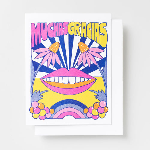 Risograph greeting card with a bold illustrated smiling mouth, two echinacea flowers, a sunburst, rainbow, and colorful bubbles in pink, yellow, and navy, text reads Muchas Gracias in large pink and yellow lettering