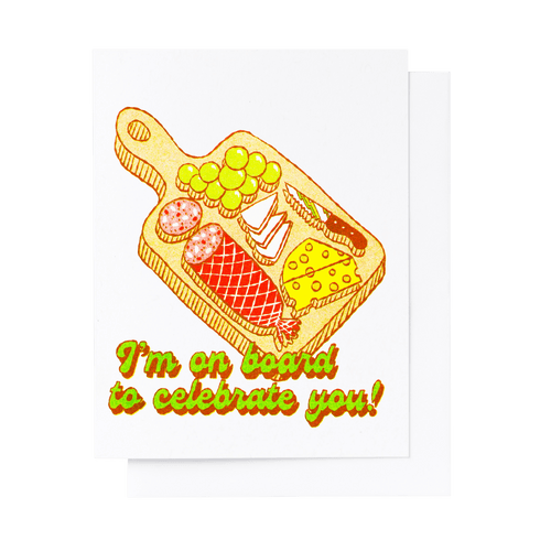 Risograph greeting card with an illustrated charcuterie board topped with salami, cheese, grapes, and crackers, text reads I'm On Board to Celebrate You in bold green and red lettering