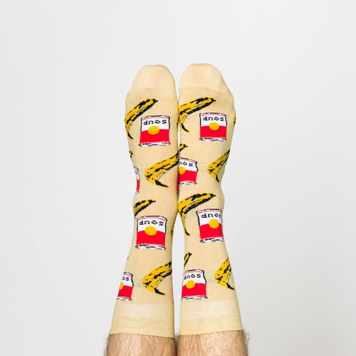 Cream Pop Art crew socks with soup can and banana print worn on feet by Yellow Owl Workshop