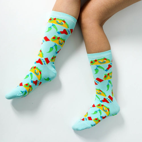 Light blue Taco crew socks with smiling taco and hot sauce print worn on feet by Yellow Owl Workshop