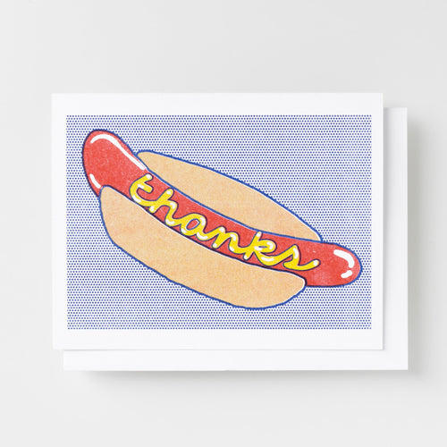 Risograph greeting card with an illustrated hot dog in a bun with mustard spelling out thanks on a blue halftone dot background